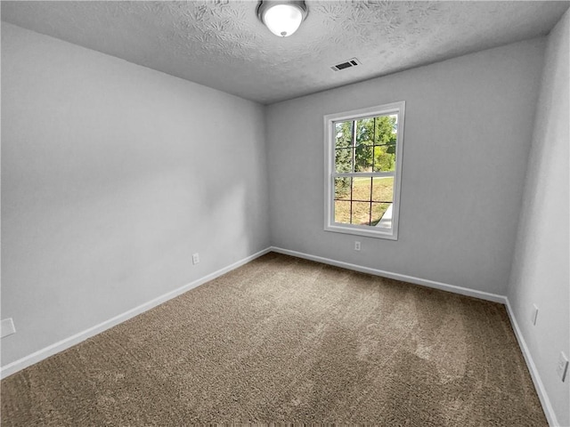 carpeted empty room with a textured ceiling, visible vents, and baseboards