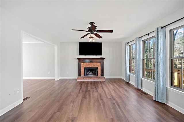 unfurnished living room featuring visible vents, a fireplace, dark wood-type flooring, and baseboards