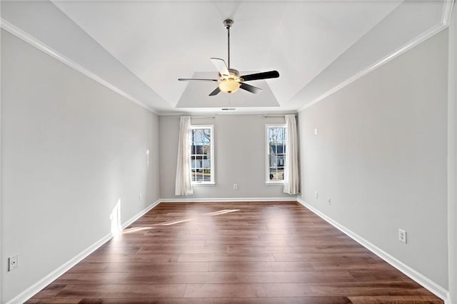 spare room with crown molding, baseboards, a tray ceiling, a ceiling fan, and dark wood-style flooring