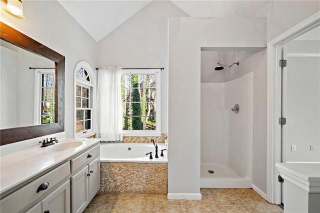 bathroom featuring tile patterned flooring, walk in shower, vaulted ceiling, a bath, and vanity