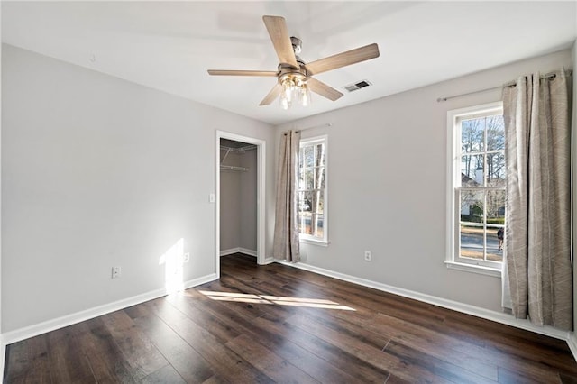 unfurnished bedroom with visible vents, baseboards, hardwood / wood-style floors, and a ceiling fan