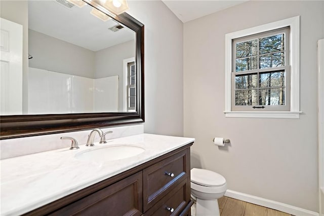 full bathroom with visible vents, baseboards, toilet, wood finished floors, and vanity