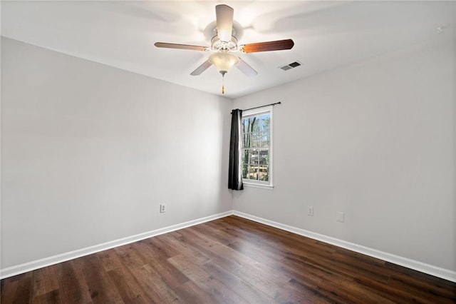 spare room featuring visible vents, ceiling fan, baseboards, and wood finished floors