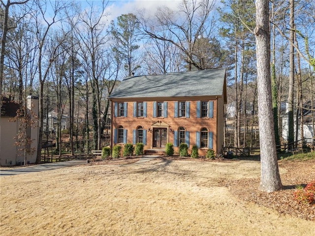 colonial home featuring brick siding