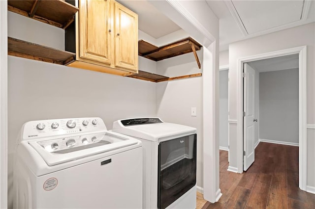 clothes washing area with baseboards, cabinet space, dark wood-style flooring, and washing machine and clothes dryer