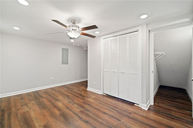 unfurnished bedroom featuring baseboards, electric panel, recessed lighting, dark wood-style flooring, and a closet