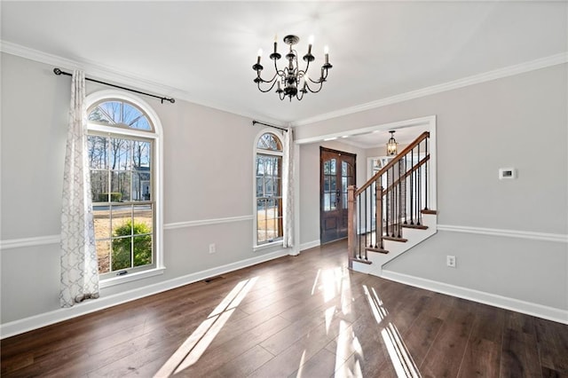 entrance foyer with stairs, a notable chandelier, wood finished floors, and baseboards