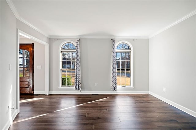 unfurnished dining area featuring hardwood / wood-style floors, crown molding, and baseboards