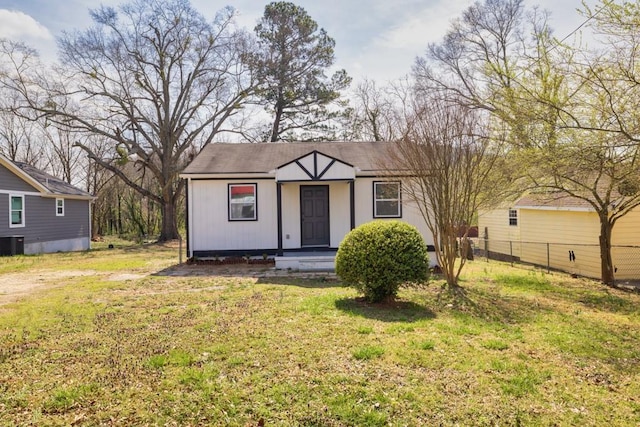 view of front facade with central AC unit, a front yard, and fence