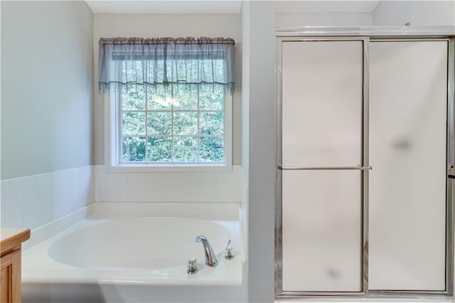 bathroom featuring vanity, a garden tub, and a stall shower
