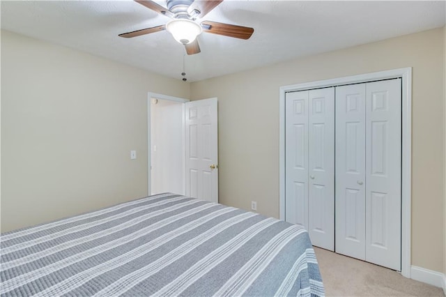 bedroom with a ceiling fan, light colored carpet, and a closet