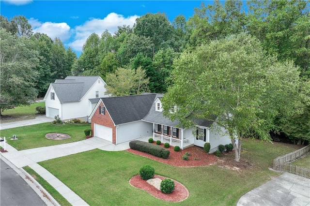 view of front of house featuring a porch, concrete driveway, a shingled roof, and a front lawn