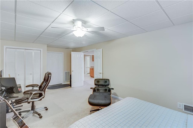 carpeted bedroom featuring visible vents, a paneled ceiling, and a closet