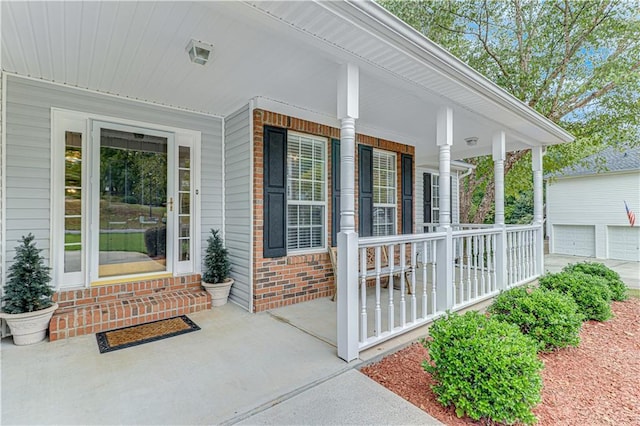 view of exterior entry with a porch and brick siding