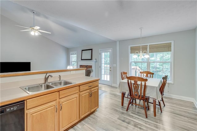kitchen featuring a sink, light wood finished floors, open floor plan, and dishwasher