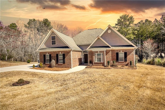 craftsman-style house with a front yard and brick siding