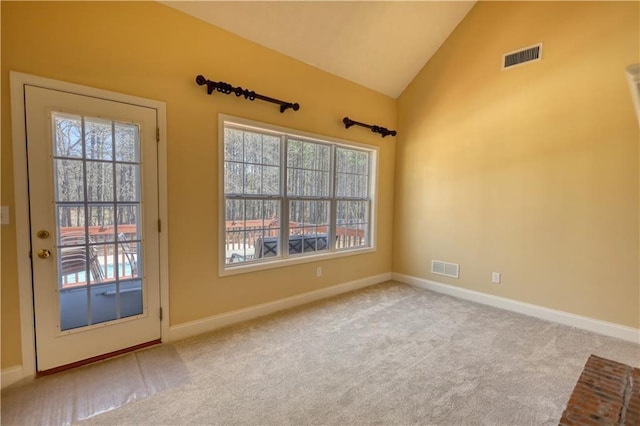 entryway with carpet floors, a healthy amount of sunlight, visible vents, and vaulted ceiling