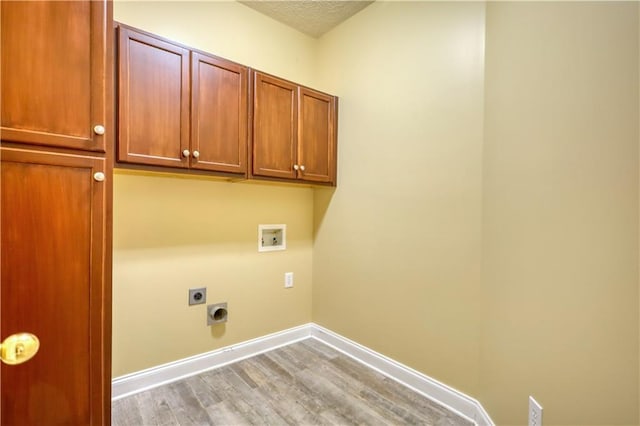 laundry area with cabinet space, baseboards, hookup for a washing machine, light wood-style floors, and electric dryer hookup