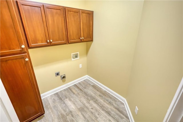 clothes washing area featuring cabinet space, baseboards, light wood-style flooring, hookup for an electric dryer, and washer hookup