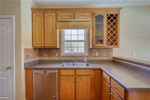 kitchen with stainless steel dishwasher, a sink, glass insert cabinets, and tasteful backsplash