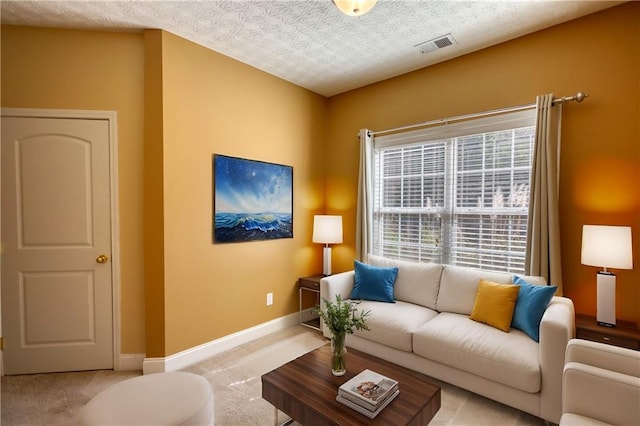 carpeted living room with baseboards, visible vents, and a textured ceiling