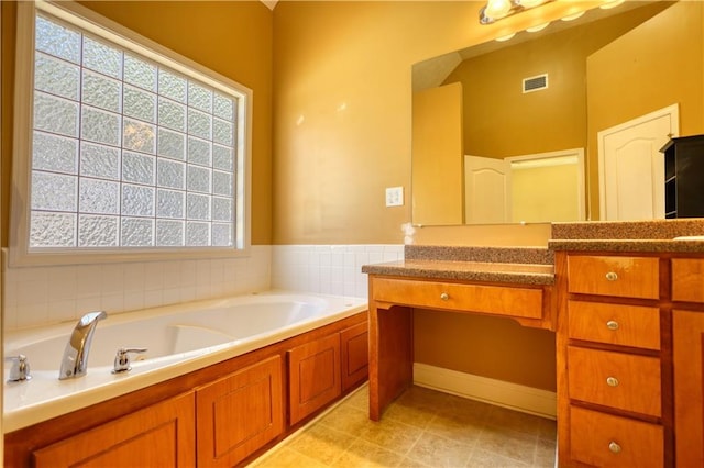 bathroom with visible vents, a garden tub, and vanity