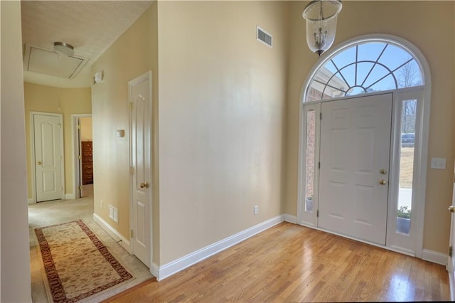 foyer featuring visible vents, plenty of natural light, light wood-style flooring, and baseboards