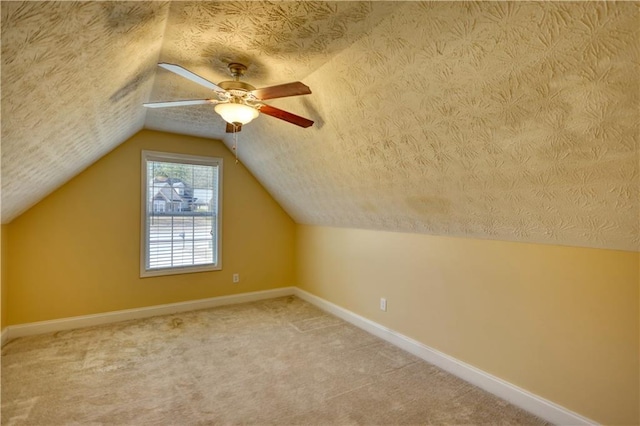 bonus room featuring carpet, baseboards, vaulted ceiling, and a textured ceiling