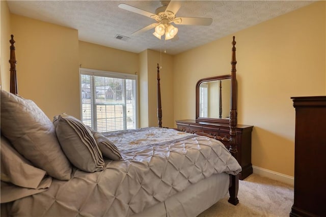 bedroom featuring baseboards, visible vents, light colored carpet, ceiling fan, and a textured ceiling