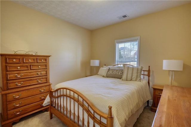 carpeted bedroom featuring visible vents