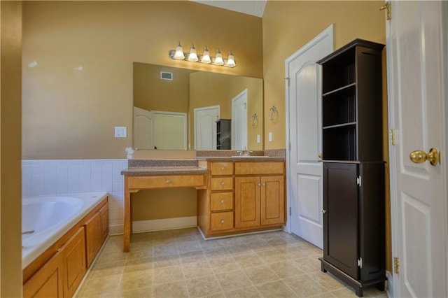 bathroom featuring visible vents, a bath, and vanity