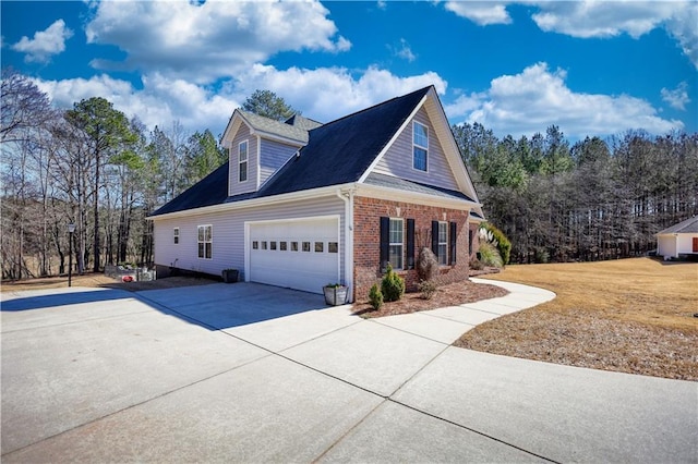 view of home's exterior with a garage, brick siding, and driveway