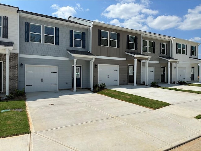 townhome / multi-family property featuring a garage, driveway, and board and batten siding