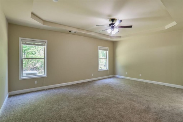 unfurnished room featuring a raised ceiling, baseboards, and carpet floors