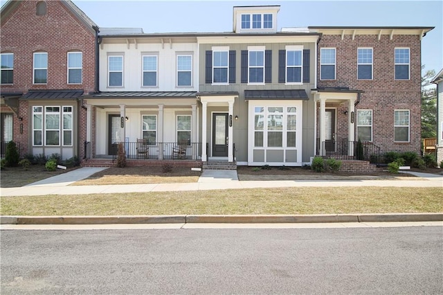 3313 Park Pointe Cir, Scottdale, GA 30079 - view of property featuring a standing seam roof, a porch, brick siding, a front yard, and metal roof