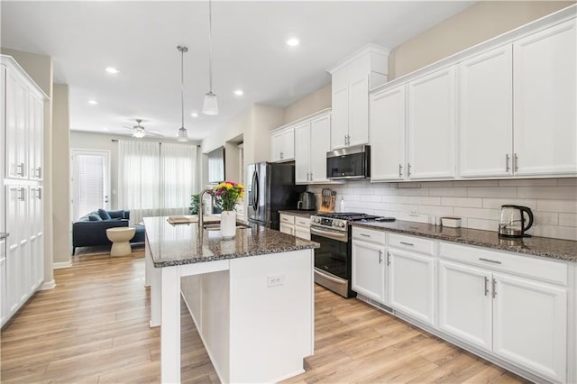 3313 Park Pointe Cir, Scottdale, GA 30079 - kitchen with appliances with stainless steel finishes, decorative backsplash, dark stone countertops, white cabinetry, and ceiling fan