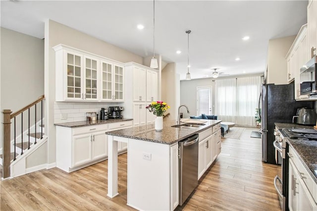 3313 Park Pointe Cir, Scottdale, GA 30079 - kitchen featuring a sink, stainless steel appliances, tasteful backsplash, a center island with sink, and white cabinetry