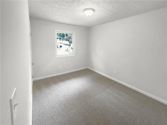 empty room with carpet floors and a textured ceiling