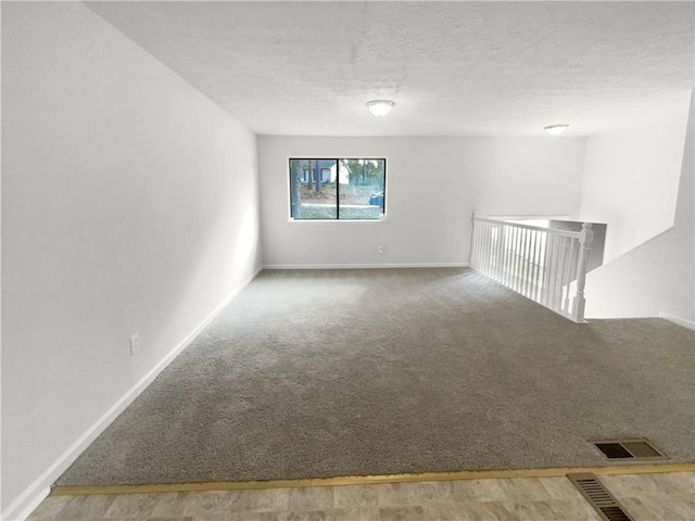 spare room with carpet flooring and a textured ceiling