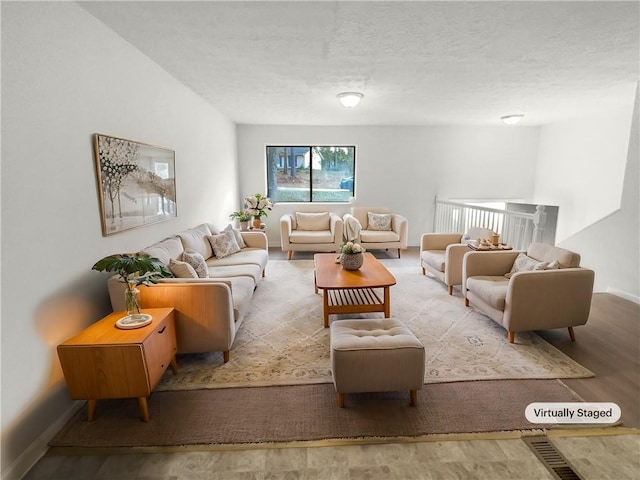 living room with light hardwood / wood-style flooring and a textured ceiling