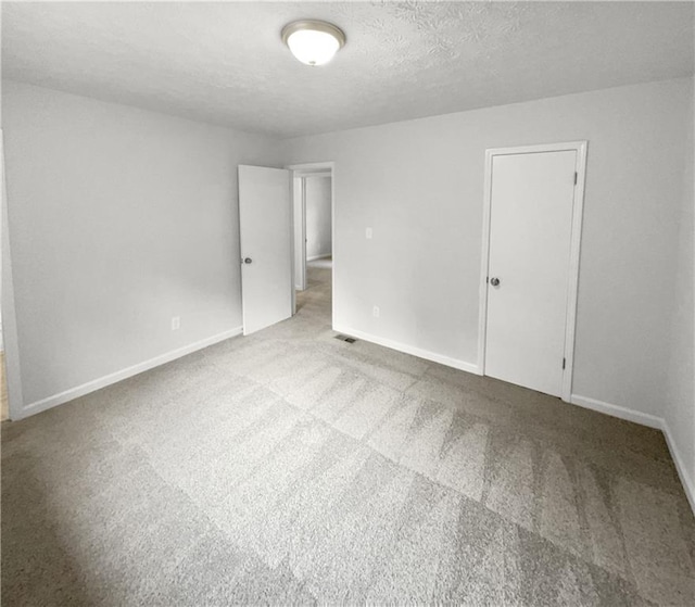 spare room with a textured ceiling and carpet floors