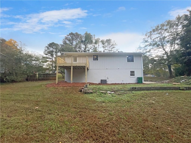 rear view of property with central AC, a wooden deck, and a lawn