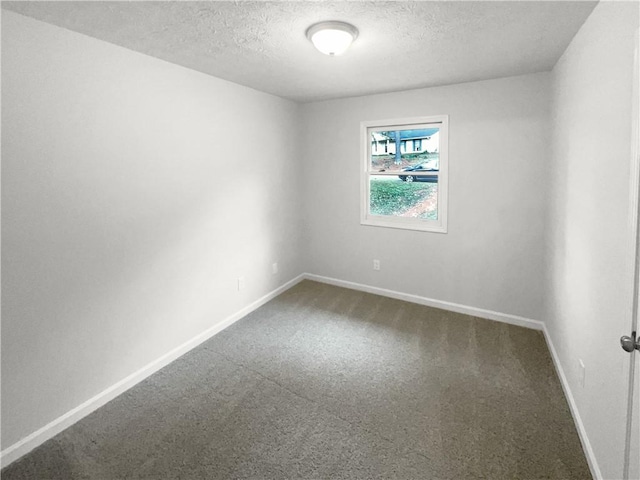 carpeted spare room with a textured ceiling