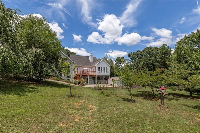 rear view of property featuring a deck and a lawn