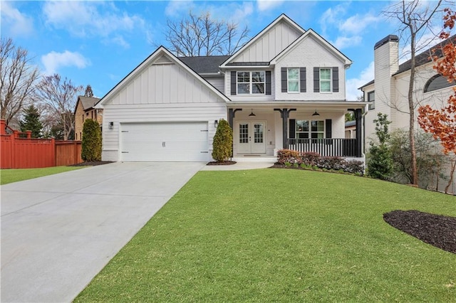 craftsman house featuring a garage, driveway, french doors, a front lawn, and board and batten siding