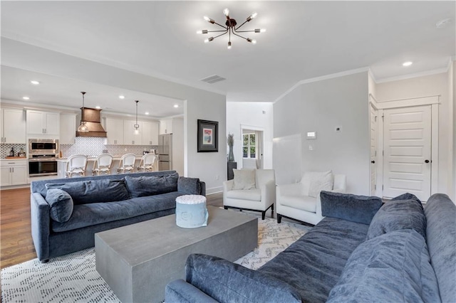 living area featuring light wood-style flooring, visible vents, ornamental molding, and recessed lighting