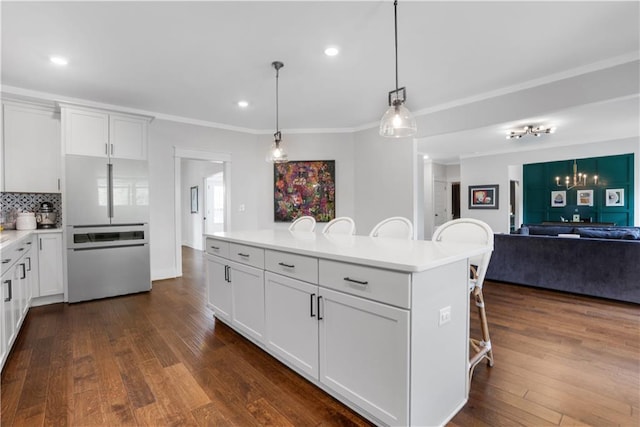 kitchen with a breakfast bar area, decorative backsplash, dark wood-type flooring, and light countertops