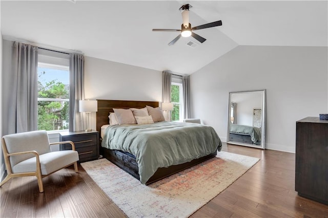 bedroom featuring visible vents, ceiling fan, vaulted ceiling, wood finished floors, and baseboards