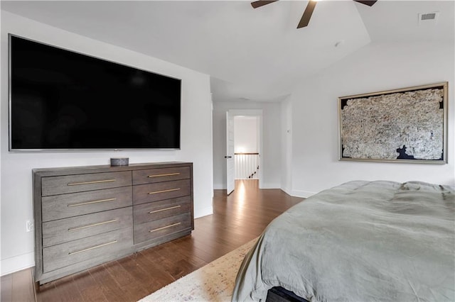 bedroom featuring dark wood-style floors, visible vents, a ceiling fan, vaulted ceiling, and baseboards