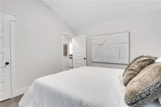 bedroom with carpet flooring, vaulted ceiling, and baseboards